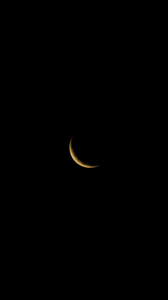Captivating view of a crescent moon set against a dark, starless night sky over Rio de Janeiro.